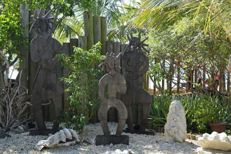 sculptures are in a sandy area and some trees