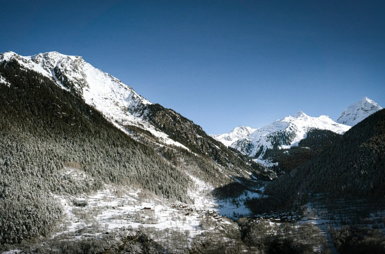 snow covered mountain tops with a clear sky in the background