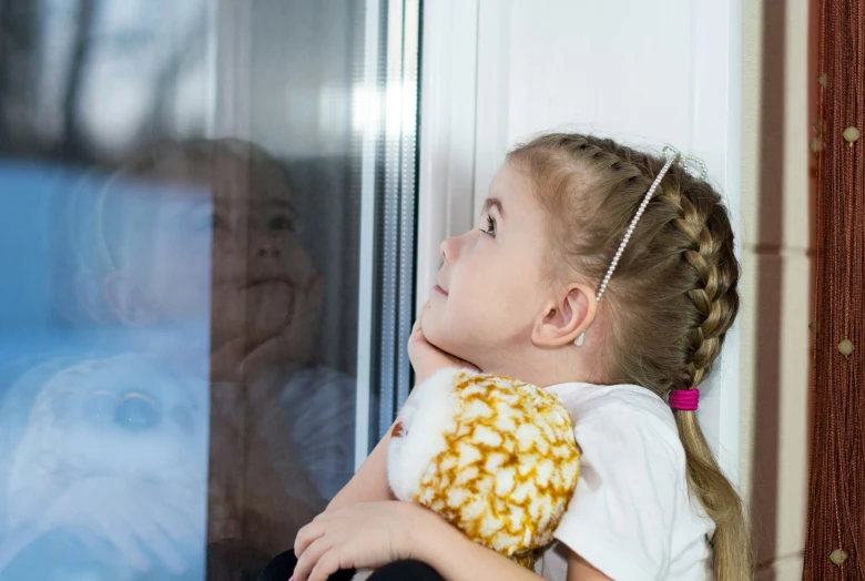 a little girl holding a donut by a door