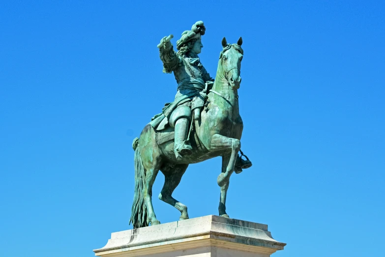 a statue of a man riding on a horse against a blue sky