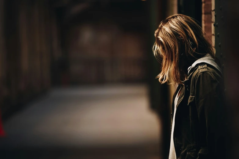 a girl is standing next to the building with her back to us