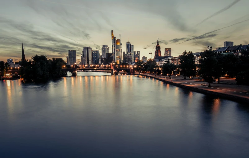 a river with light on it, a city and sky line