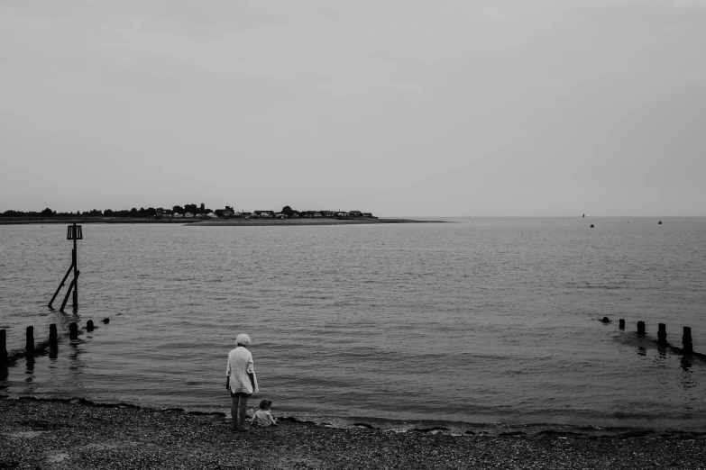 the lone person stands on the edge of the water
