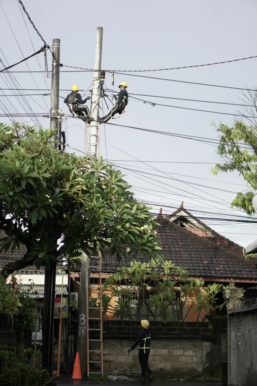 a couple of men standing next to a power line