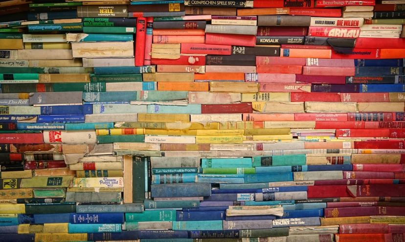 the multicolored books are piled up on top of each other