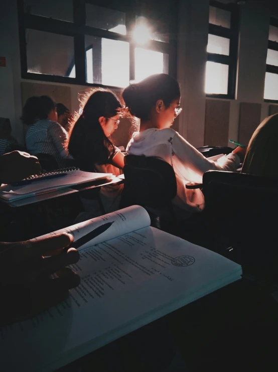 a group of s at desks with a book on them