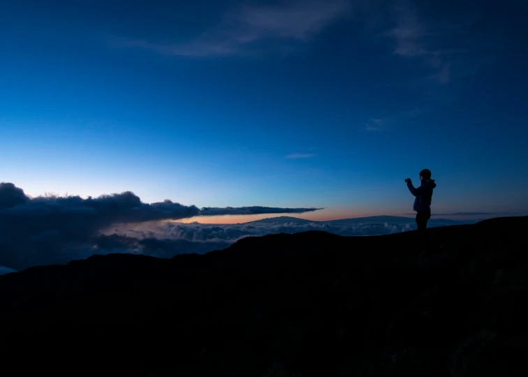 a person standing on top of a mountain above clouds