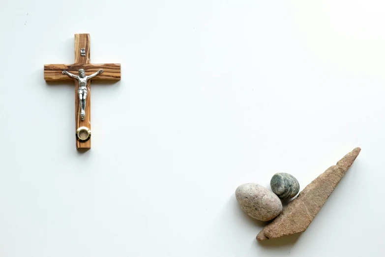 a cross and two rocks are placed in front of the rock sculpture