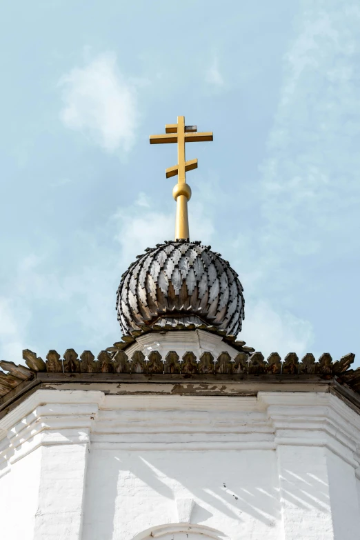 a cross and a building with some clouds