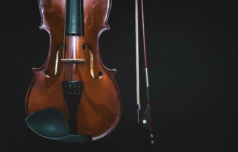 an old violin and a black bow laying on top of it