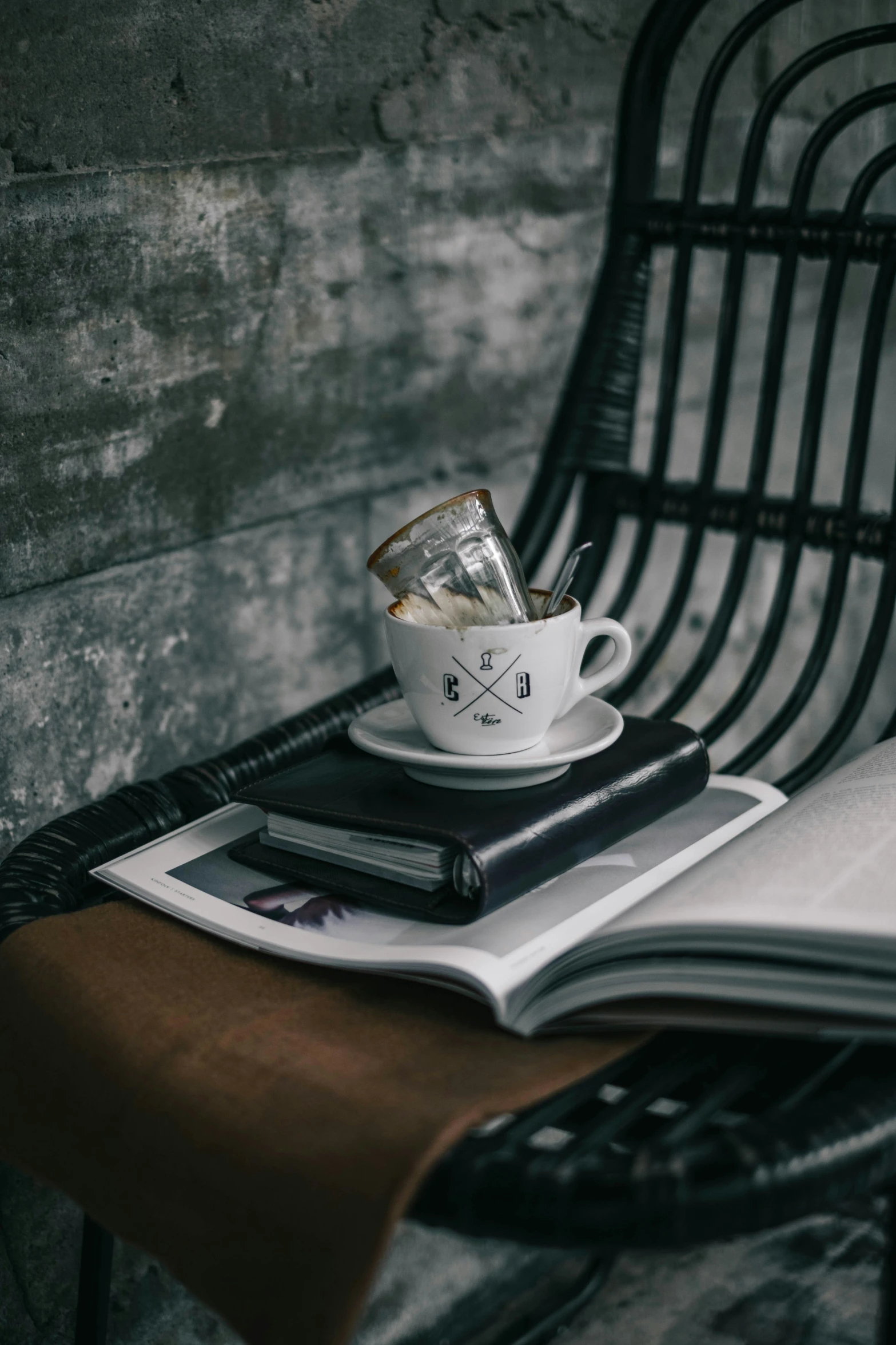 a coffee cup with a newspaper cover and some other items on top of a table