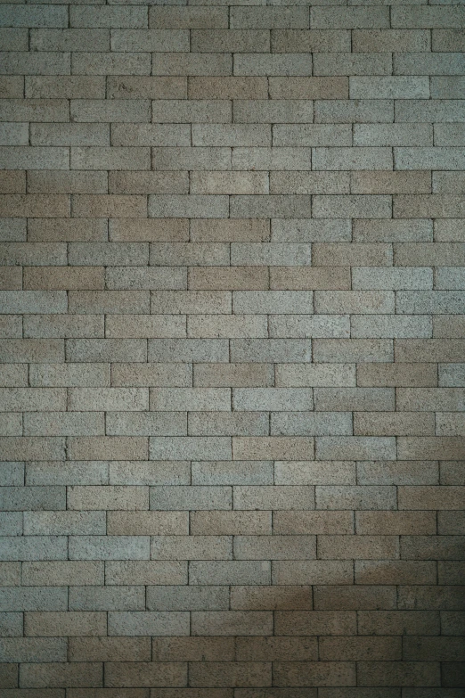 a man holding an umbrella in front of a brick wall