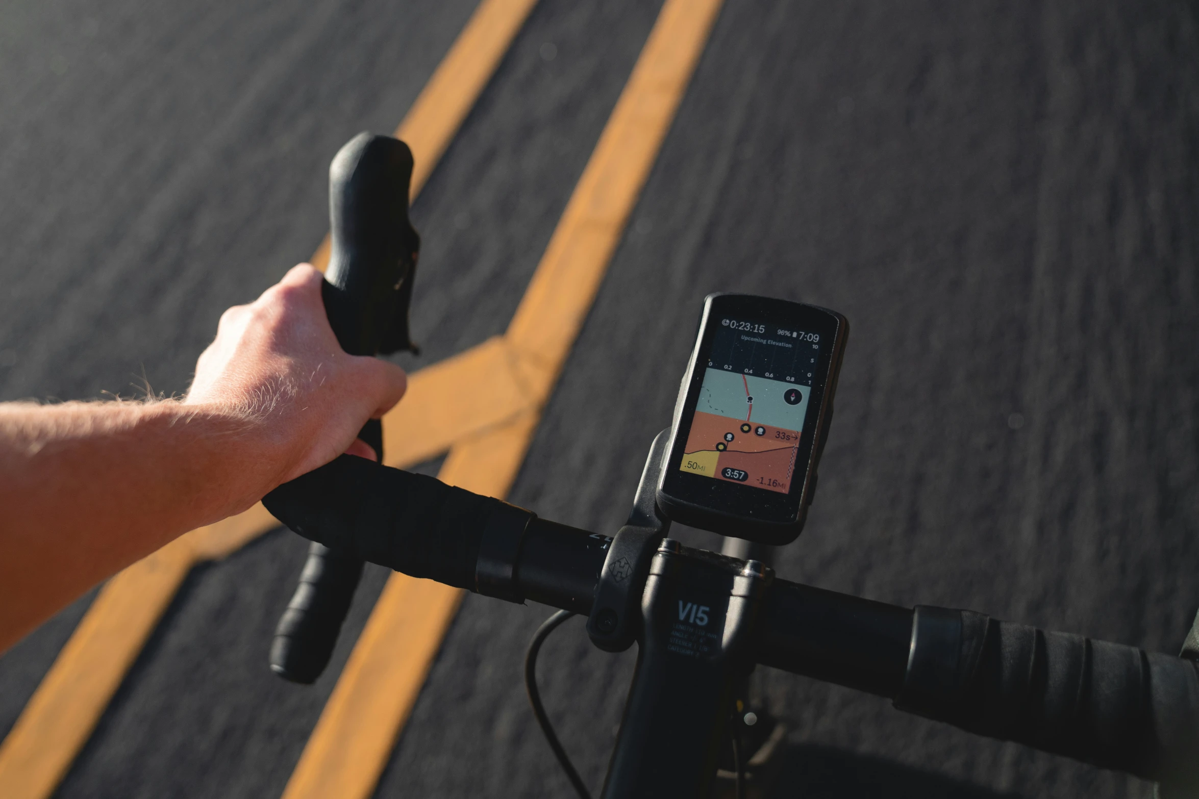 the hand is holding a bicycle handle with gps