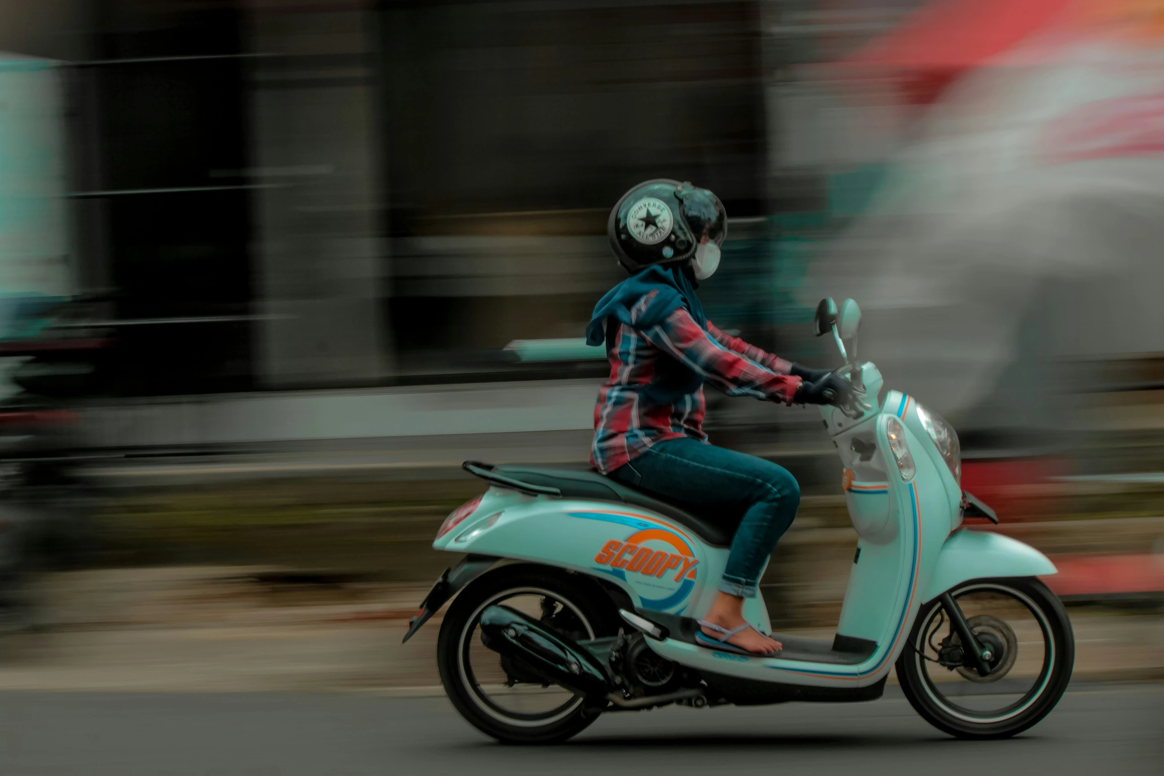 a woman is on a small blue motorcycle