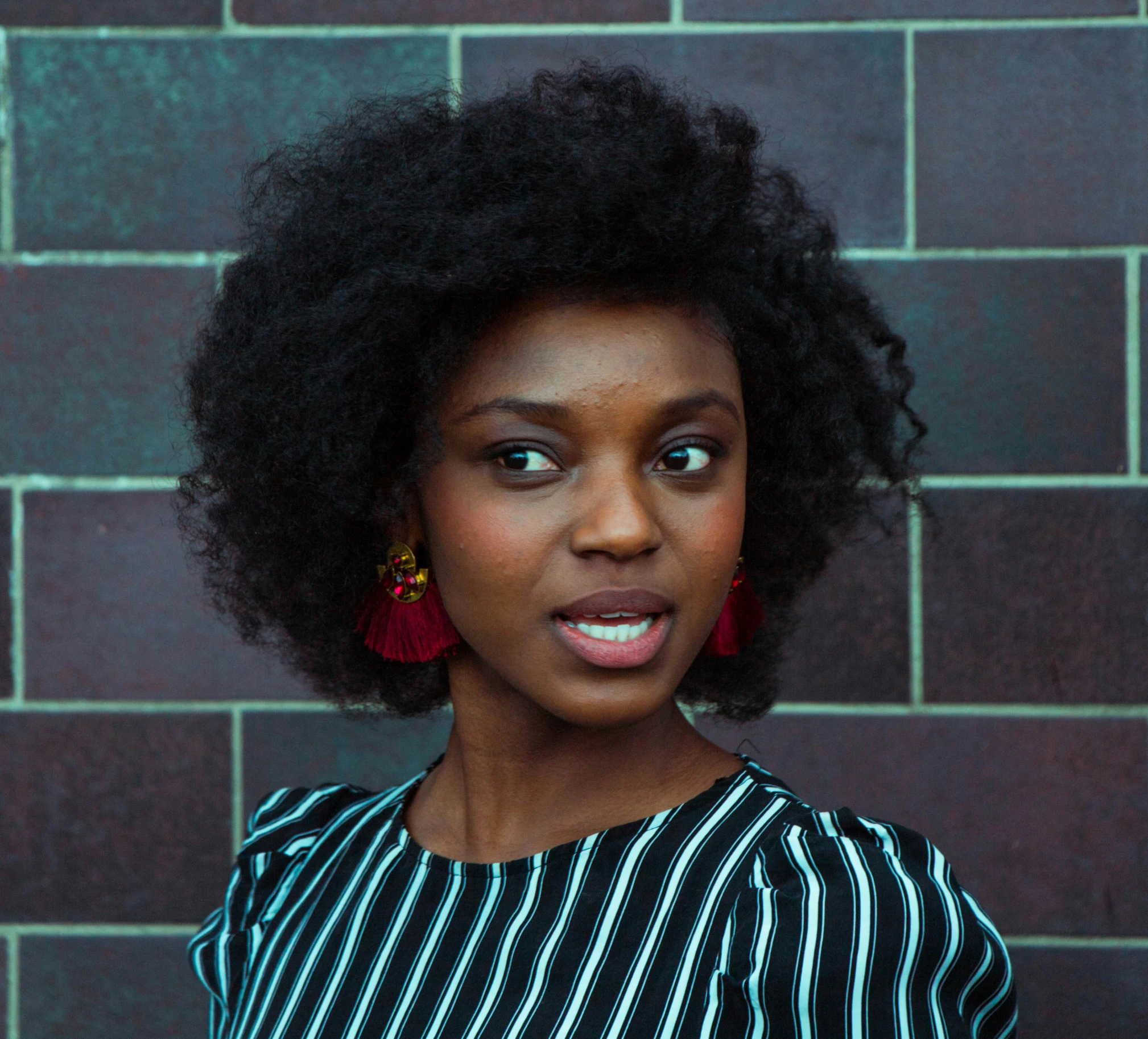 a woman wearing red earrings looking into the distance