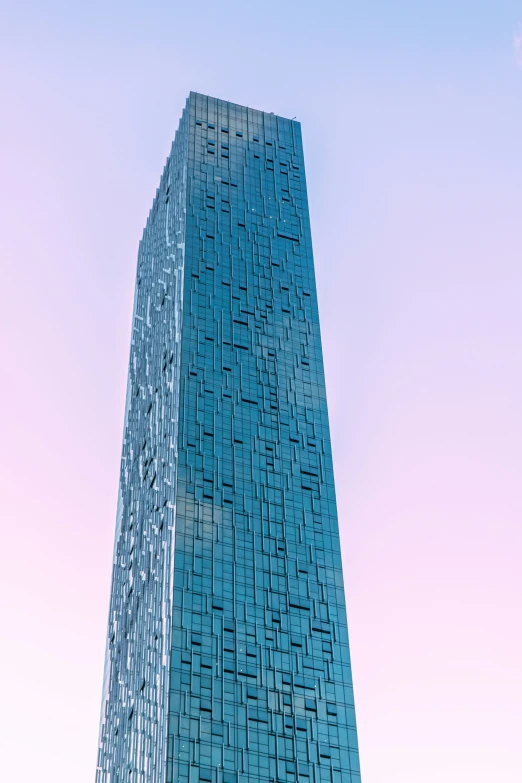 a tall glass building with the sky in the background