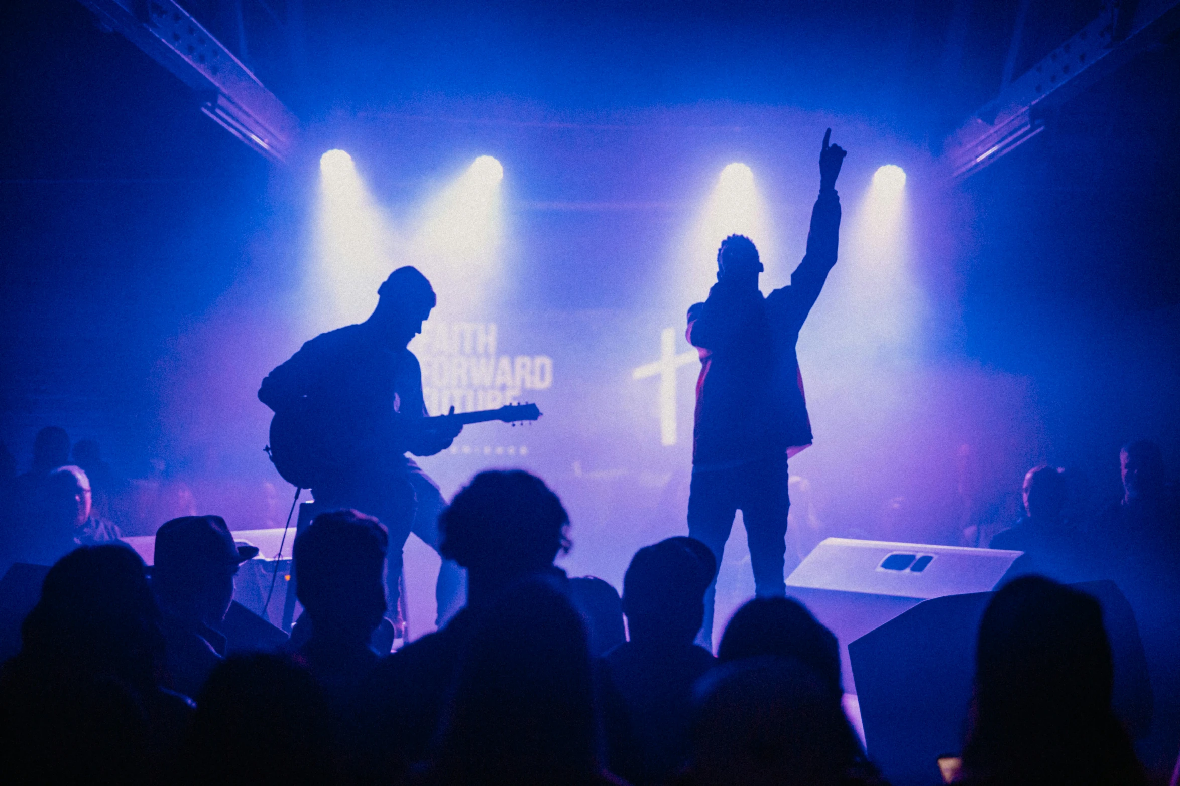 a crowd in front of some microphones at night