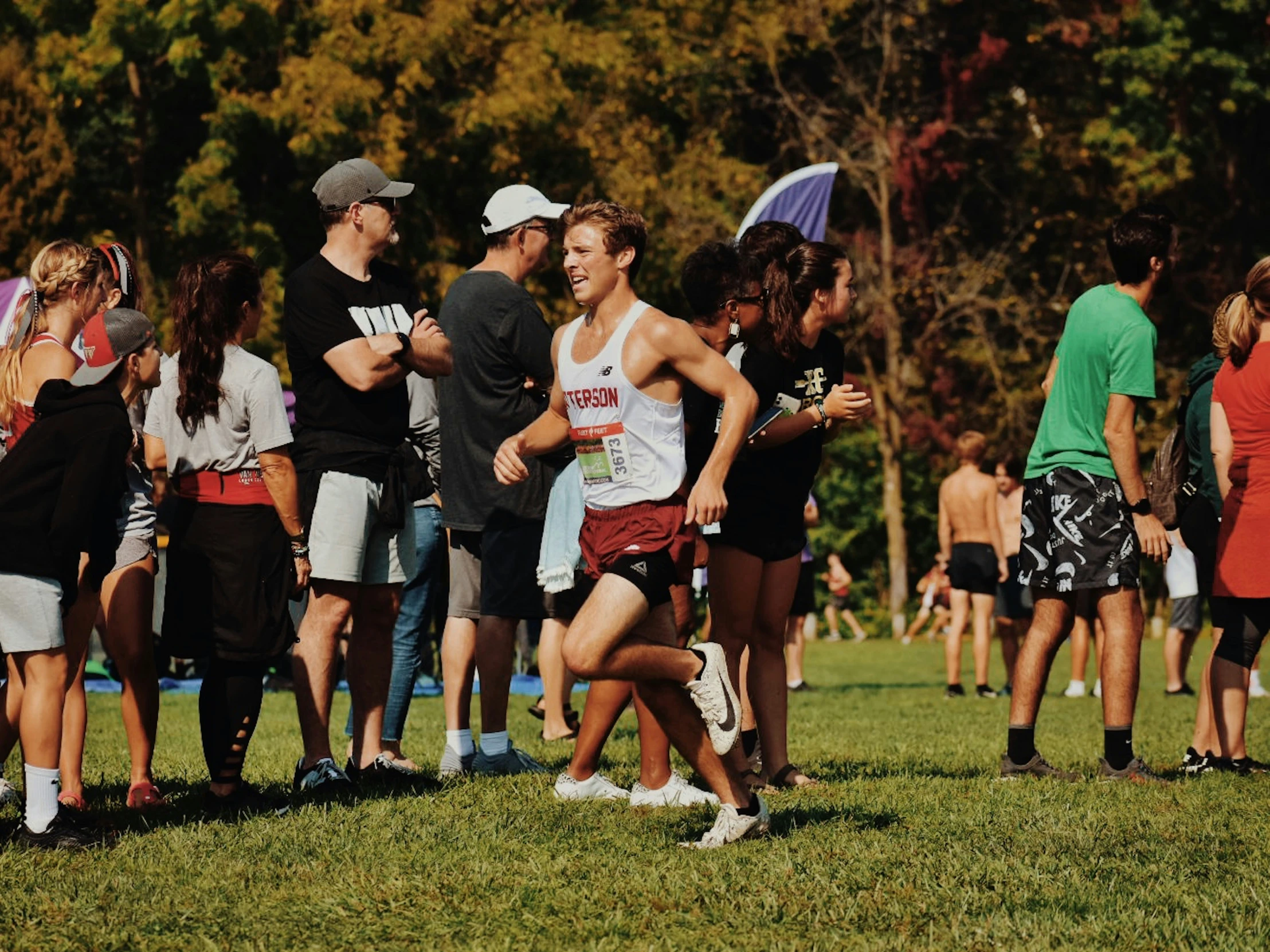 the men are running down the grass in a race