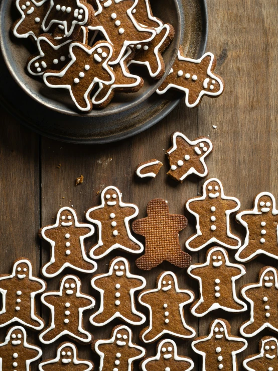 several ginger cookies with white frosting sit on a plate