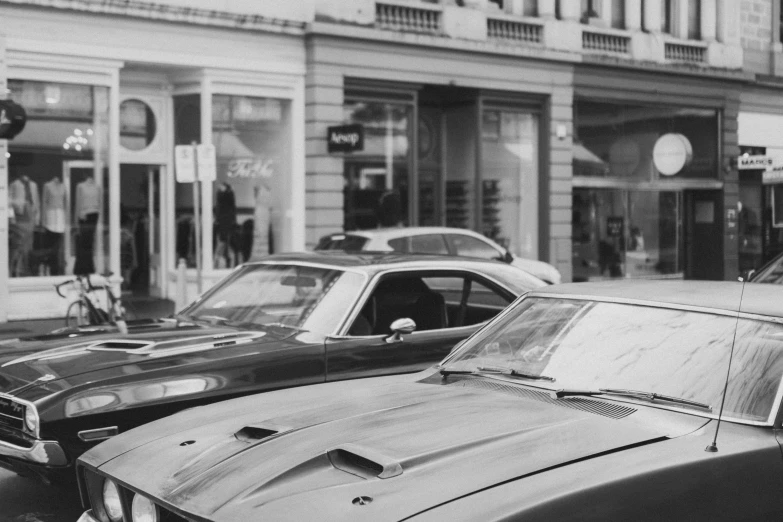 black and white image of old mustang parked on the side of the road