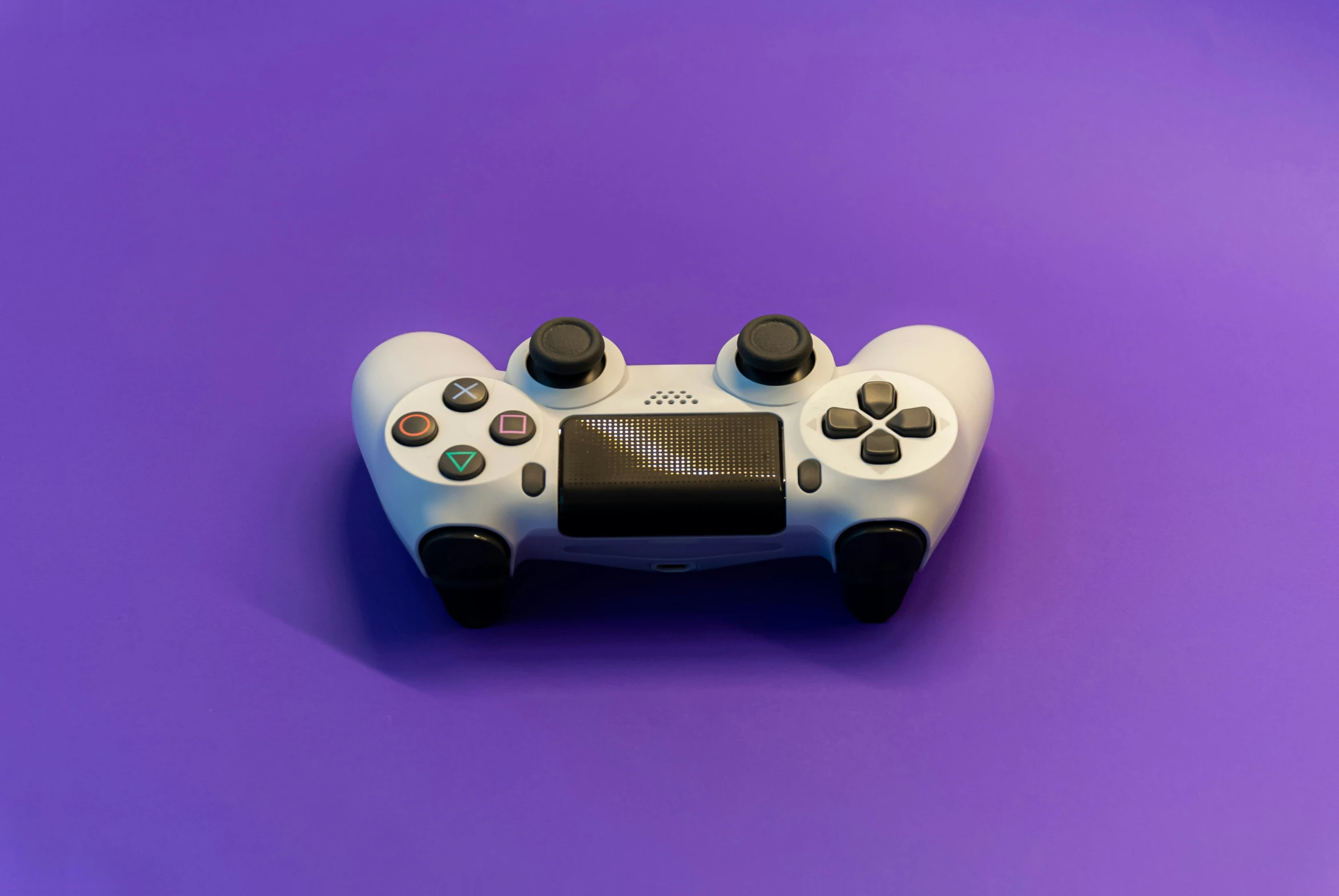 a white nintendo wii game controller is on a purple background