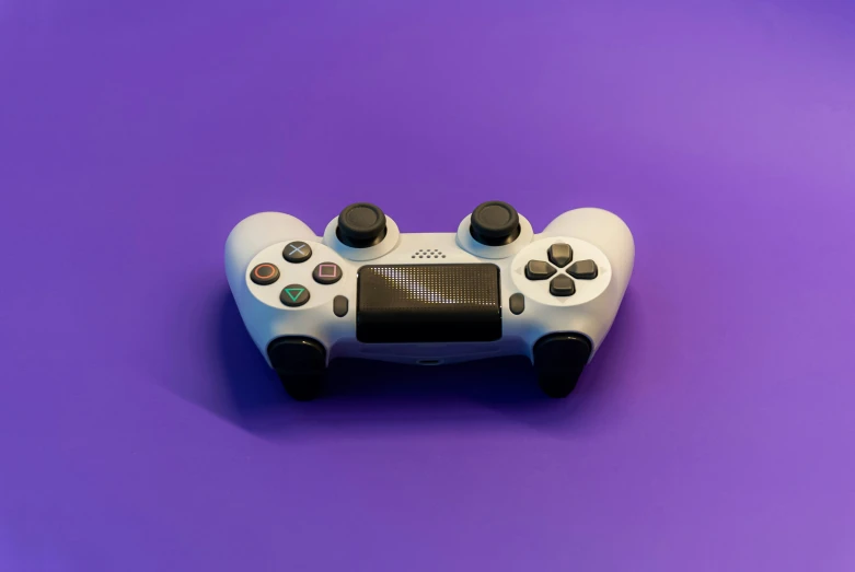 a white nintendo wii game controller is on a purple background