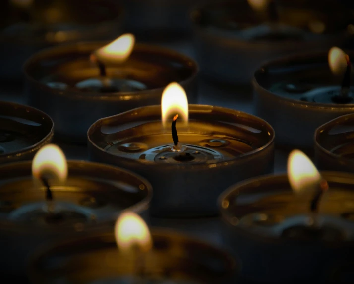 a bunch of candles that are sitting in some cups