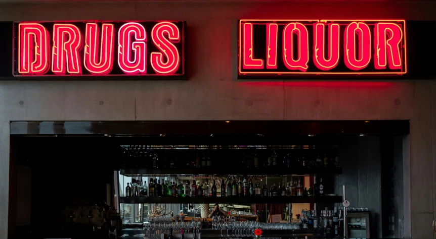 the neon sign for  liquor is glowing red