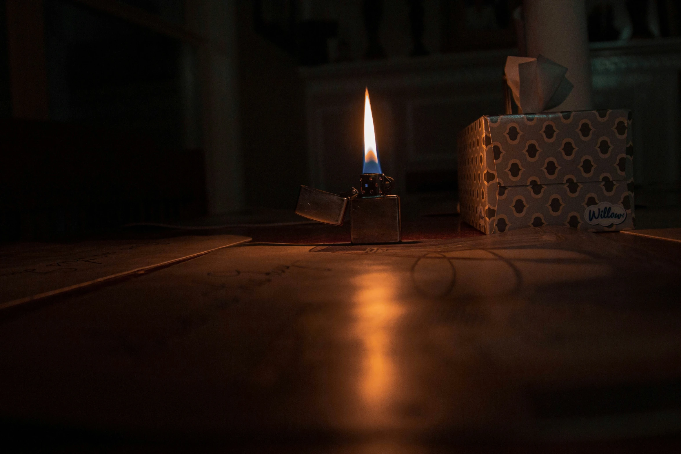 a lit candle is sitting on a brown tiled floor