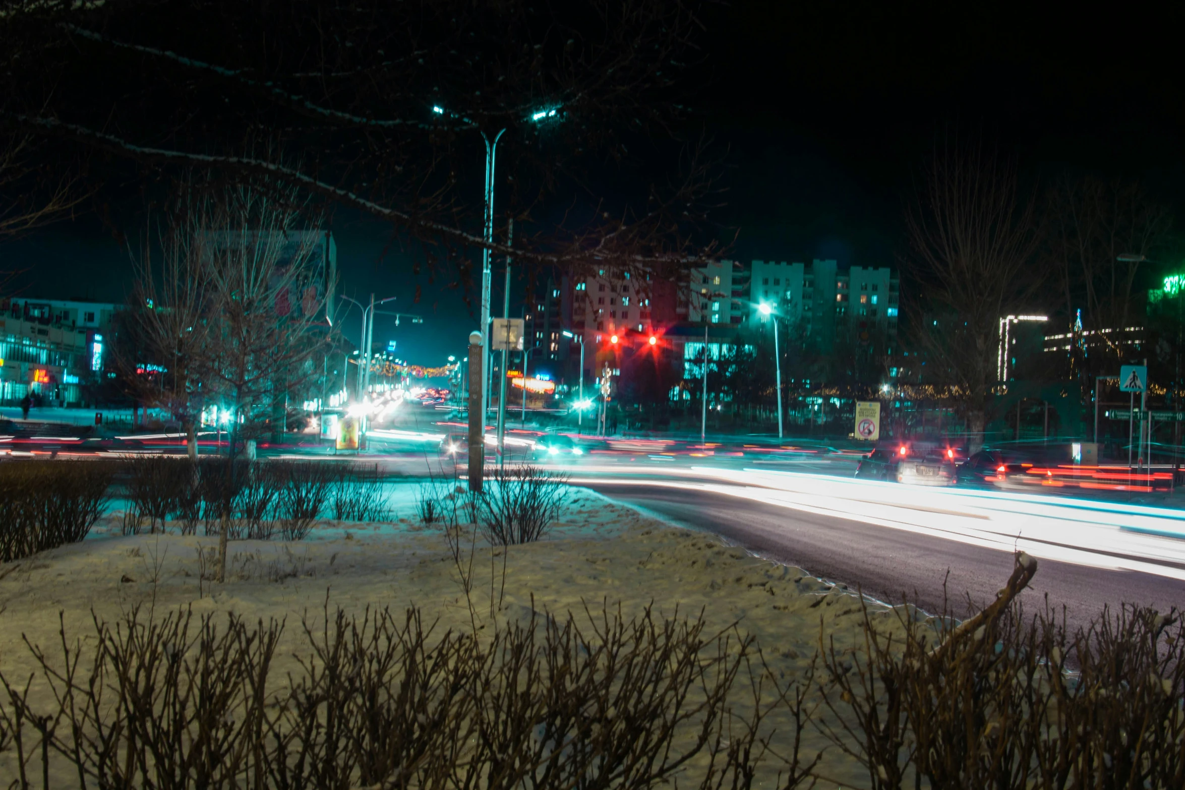 a city street at night with traffic lights