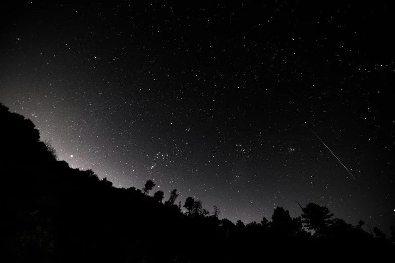 stars over mountains lit by a dark sky