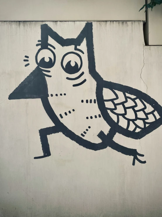 an animal with large eyes sitting on a cement wall