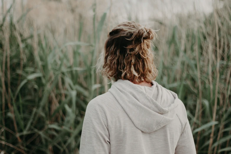 woman standing in front of green field with vegetation