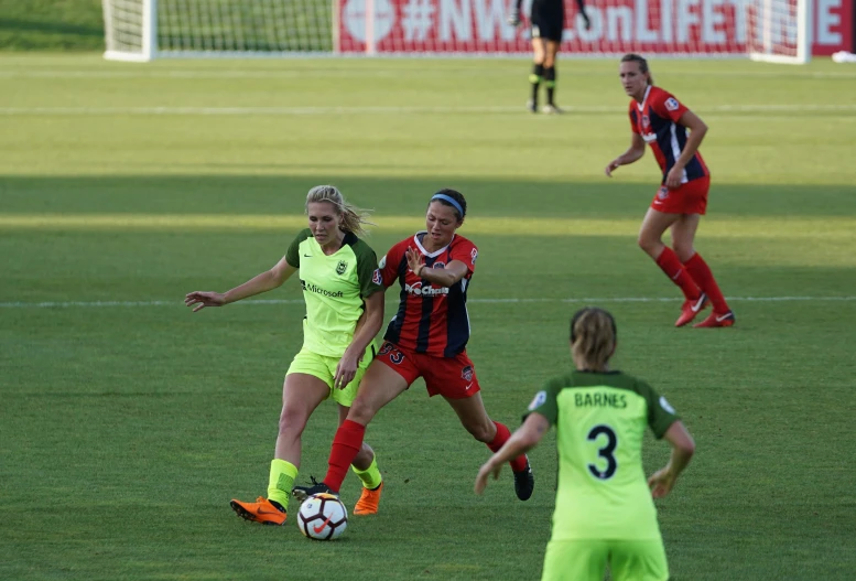 a group of women are playing soccer on a field