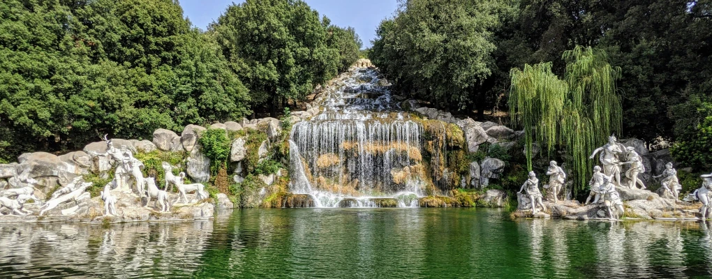 a colorful water fall in a park surrounded by trees