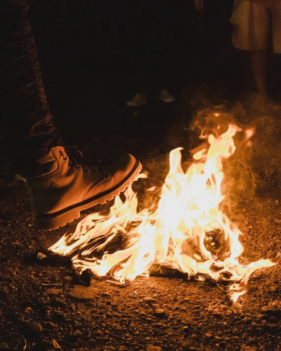 a boot is sitting on the ground by a fire