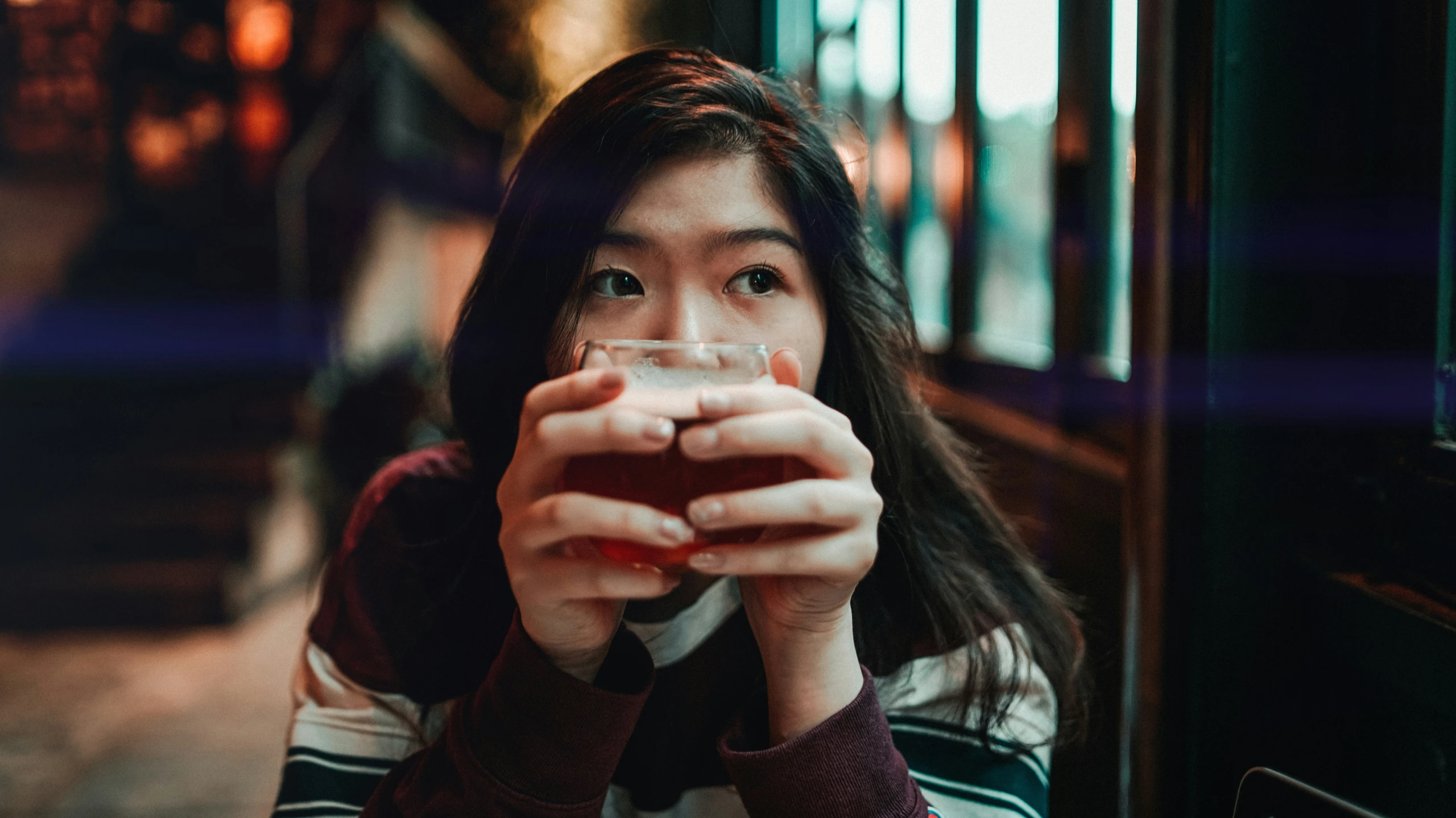 a woman holding a glass in her right hand