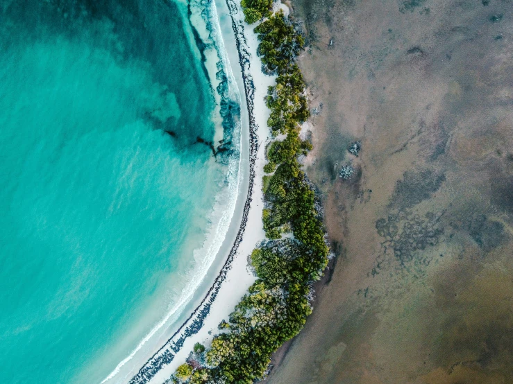 an aerial po of a beach and some green water