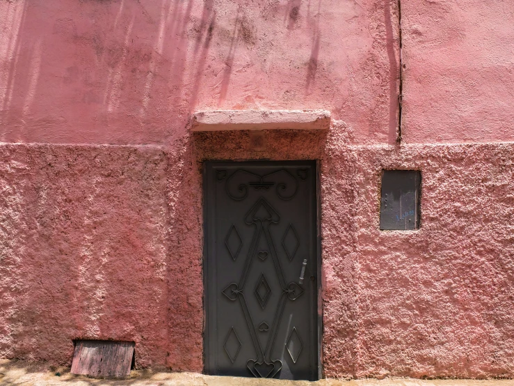 a wall with a doorway on the outside with an animal head sticking out of it