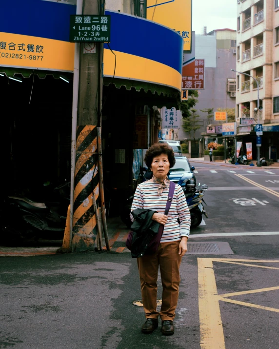 a woman stands near a road with her back to the camera