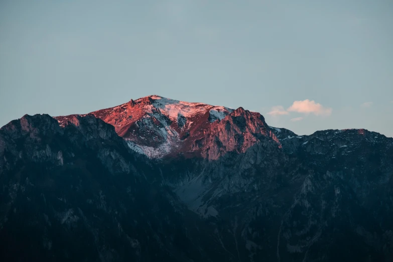 the mountain range is silhouetted against a clear blue sky