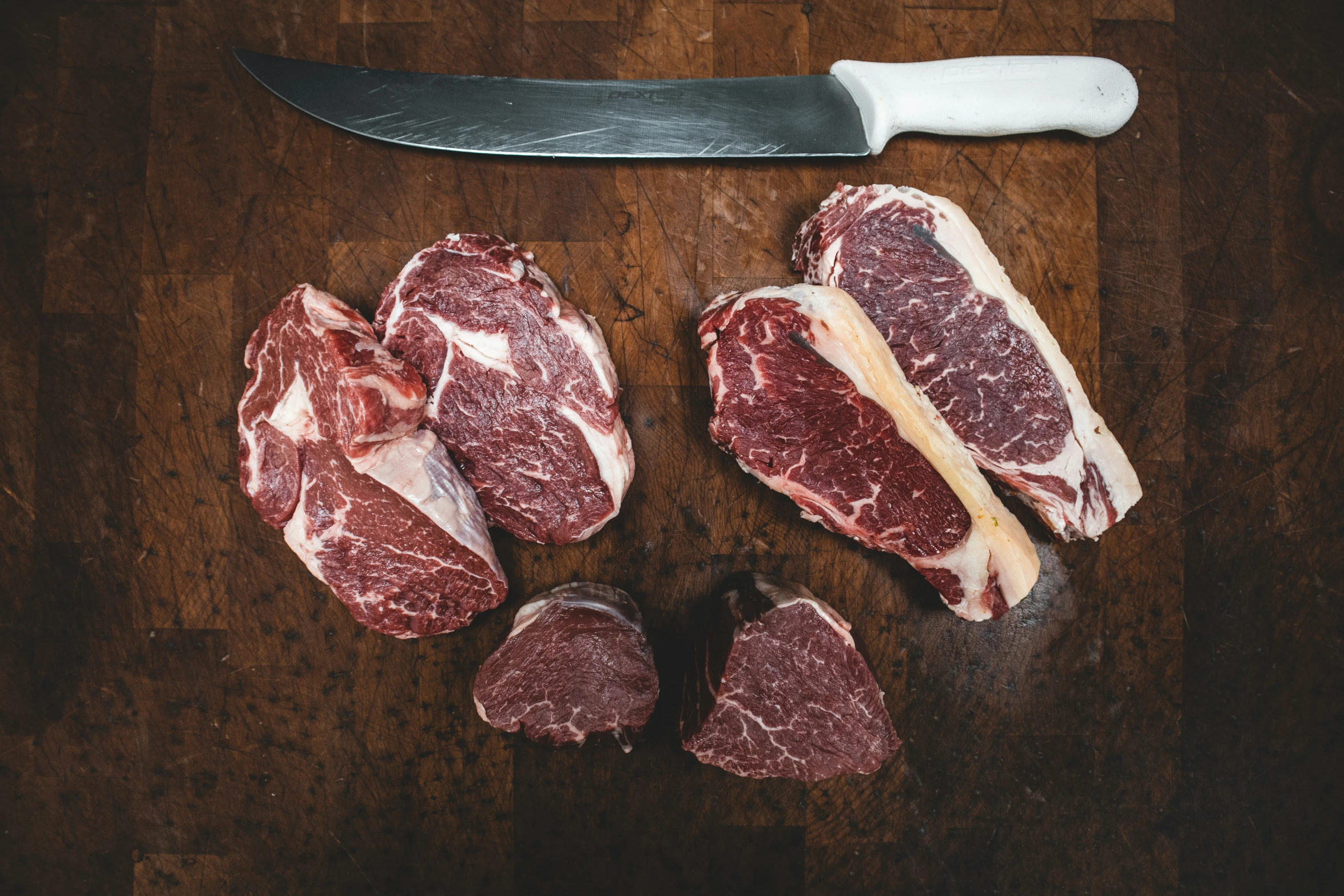 a  board with raw meat and a knife