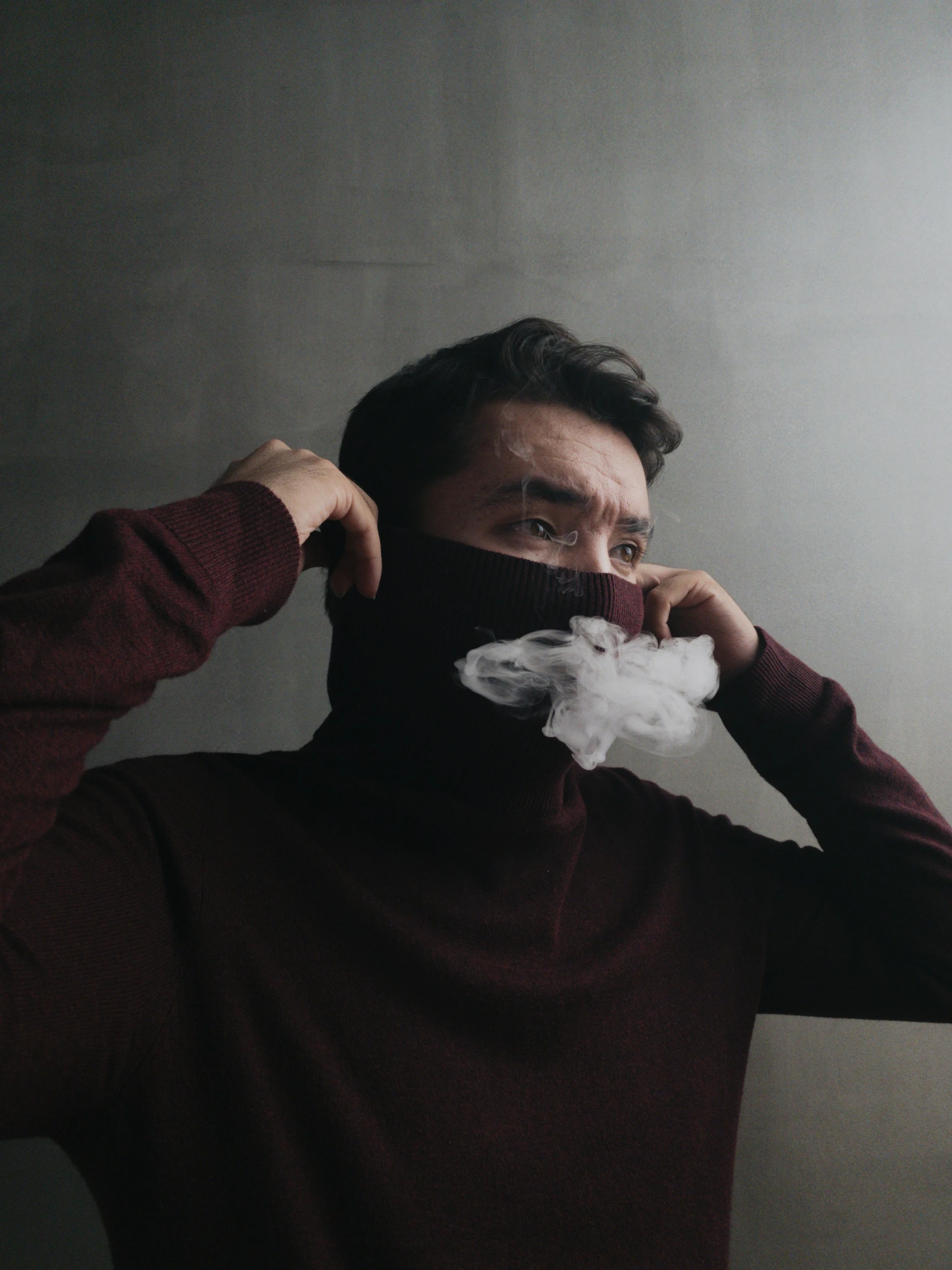 a man is covering his face with a piece of tissue