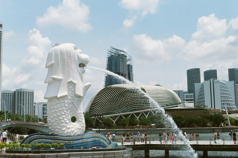 a large statue in a park with water shooting out of it