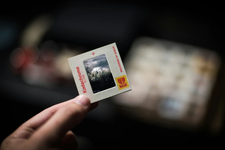 a person holding up a piece of white paper with pictures on it