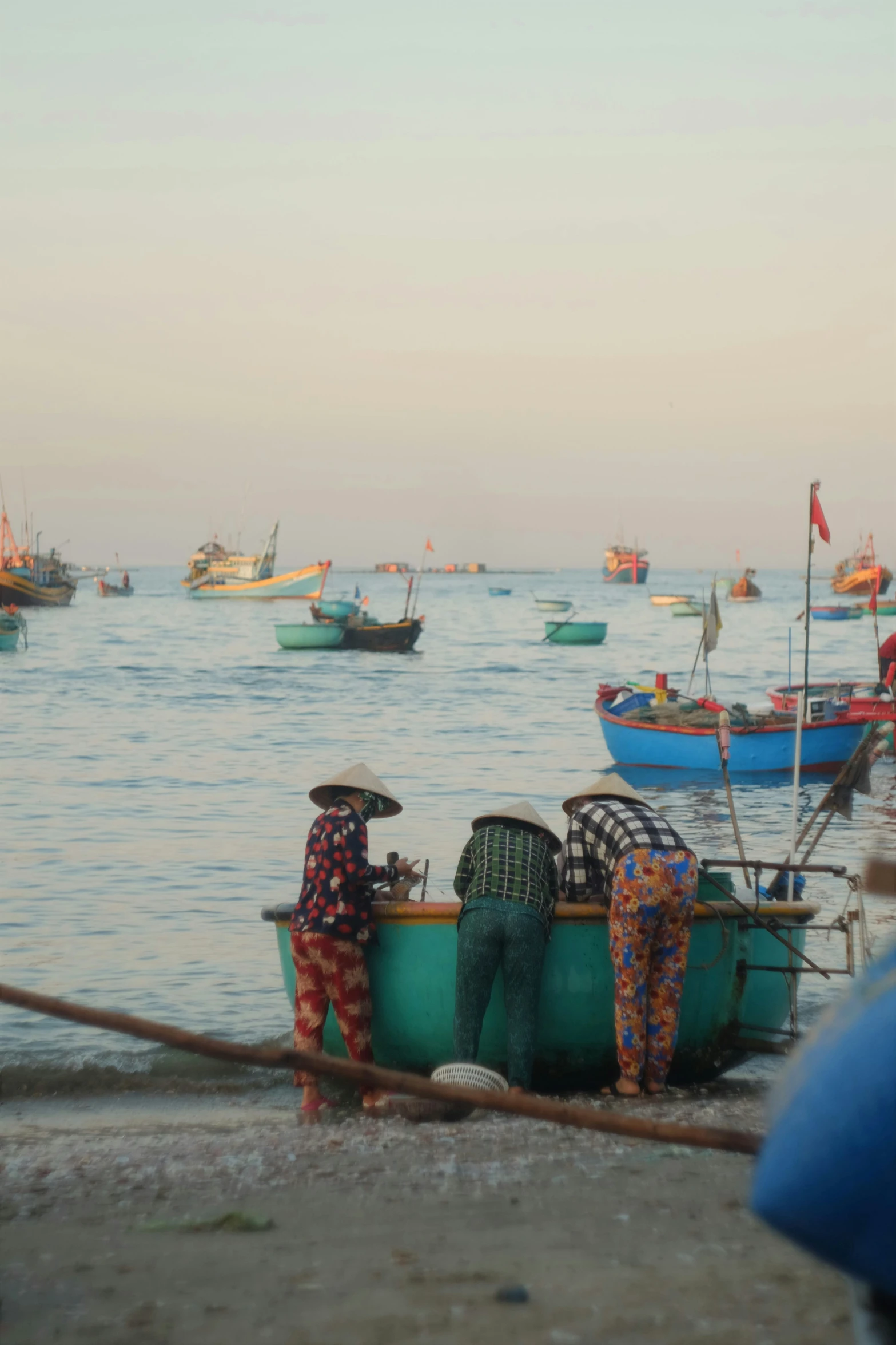 men prepare to work in small boats on the water