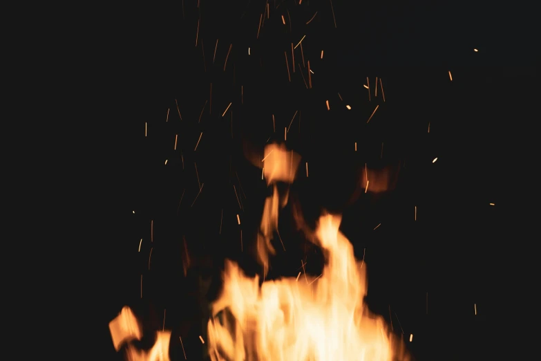 a dark picture with a blurry fire in the dark