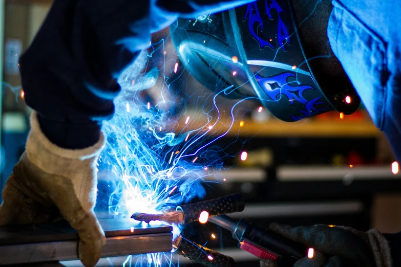 welders work on a piece of steel in an industrial area