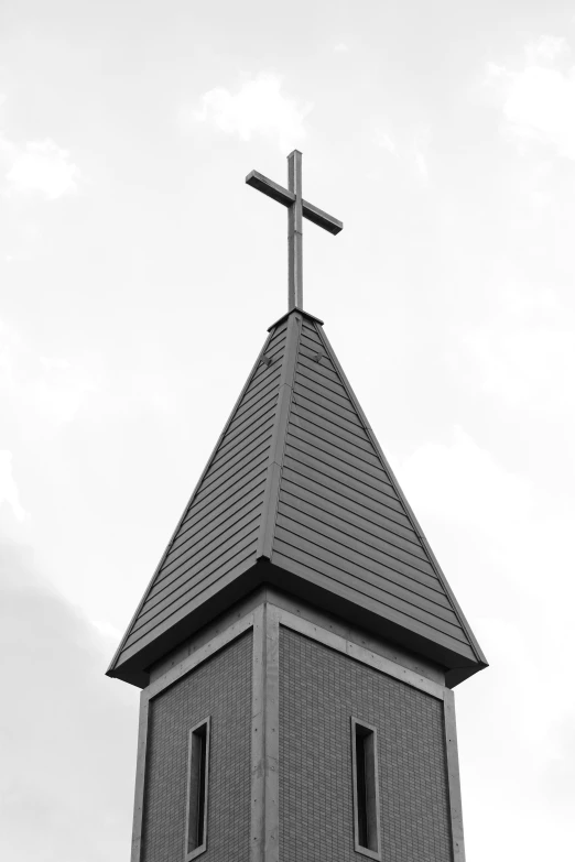 the steeple of an old brick church with a cross on top