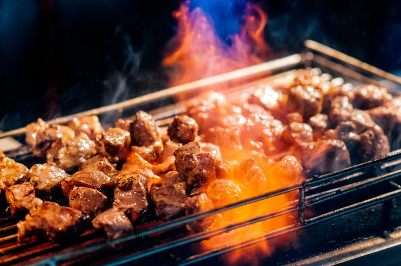 meat and potatoes on a grill being cooked